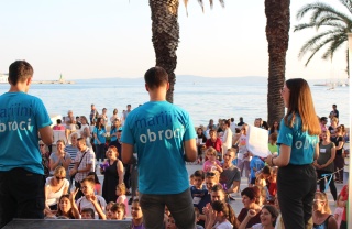 three speakers on a stage with backs to camera talking to audience