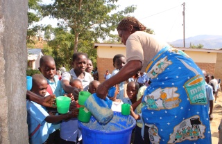 A woman giving out food to children