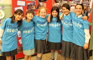 group of children with arms round each other smiling for a photo