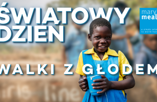 Dziewcznka trzymająca kubek z napisem Światowy Dzień Walki z Głodem