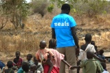 A volunteer worker talking with a group of small children