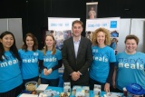 line of people at a fundraising stand standing for a photo