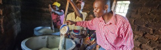 Man stirring a large iron pot of porridge