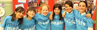 group of children with arms round each other smiling for a photo