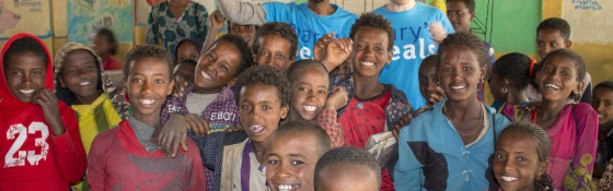 Group of children and volunteers smiling for a photo
