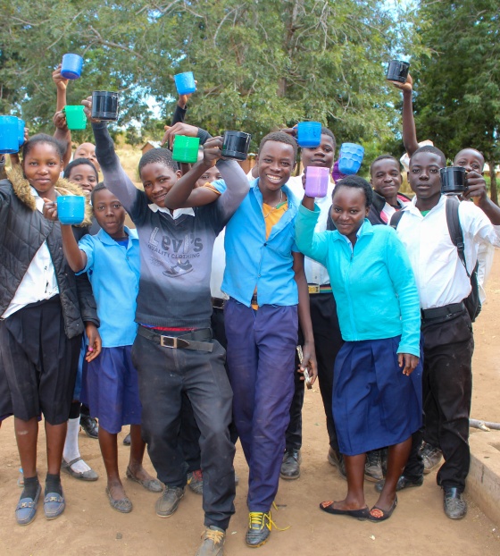 A group of children holding mugs up to the camera