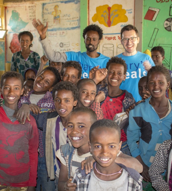 Group of children and volunteers smiling for a photo