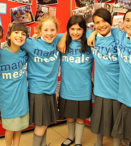 group of children with arms round each other smiling for a photo