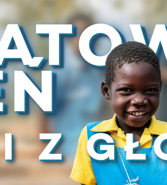 Dziewcznka trzymająca kubek z napisem Światowy Dzień Walki z Głodem