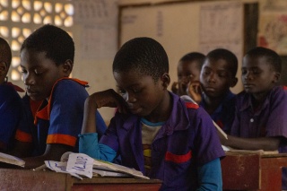 Children in a classroom looking at books on their desks