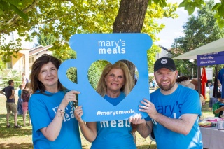 Three supporters holding a mug shaped cut-out with a heart shaped hole in the centre