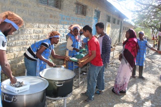 A queue of people receiving food aid from an Internally Displaced People's centre