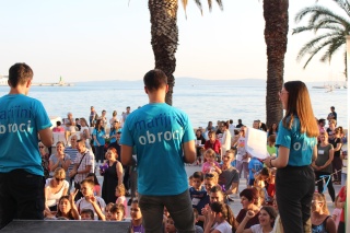 three speakers on a stage with backs to camera talking to audience