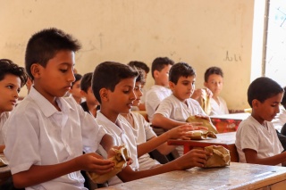 group of boys sitting at a desk in school 