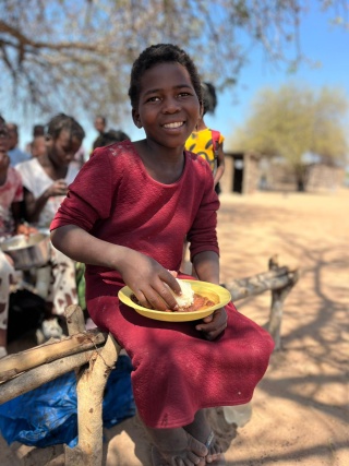 Efigênia eating her school meal